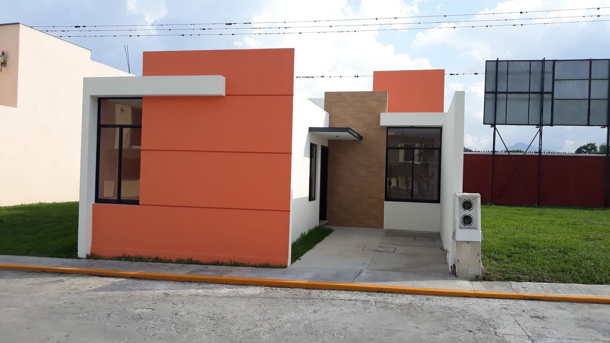 Casa de una planta con volúmenes terracota, blanco y madera