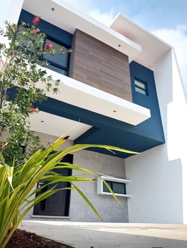 Residencia de dos niveles con volúmenes blancos, azul profundo y madera